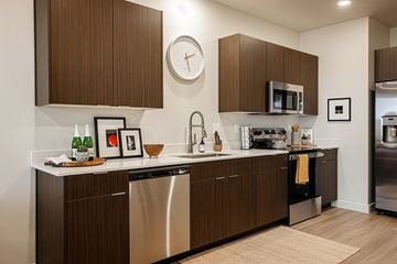 Bluffdale townhouse for rent - A modern kitchen with dark wood cabinets and stainless steel appliances.