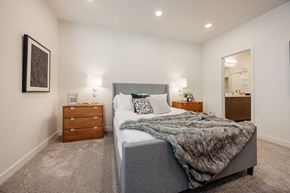 Bluffdale townhouse for rent - A bedroom with a large bed and a nightstand with a lamp.
