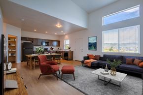 Bluffdale townhouse for rent - A modern living room with a kitchen area in the background.