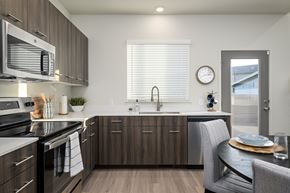 Pleasant Grove townhouse for rent - A modern kitchen with dark wood cabinets and stainless steel appliances.
