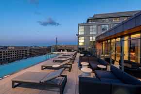 Washington apartment for rent - A rooftop pool area with lounge chairs and tables.