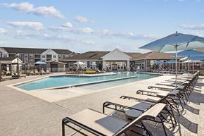 Fredericksburg apartment for rent - a swimming pool with chairs and umbrellas at the resort on a sunny day