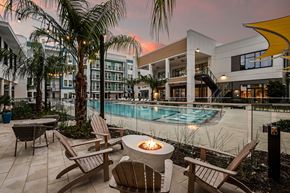 Jacksonville apartment for rent - a swimming pool with chairs and a fire pit