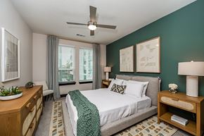 Jacksonville apartment for rent - a bedroom with a large bed and a ceiling fan