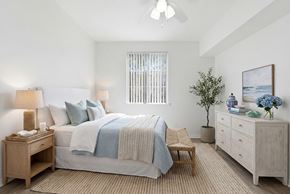 Chula Vista apartment for rent - A bedroom with a bed, nightstand, and a plant.