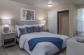 Beaverton apartment for rent - a bedroom with a bed and two nightstands and a door to a bathroom