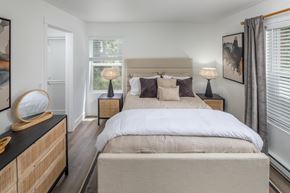 Tigard apartment for rent - A bedroom with a large bed and a wooden dresser.