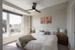 Minneapolis apartment for rent - A bedroom with a large bed and a ceiling fan.