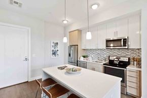 Medford apartment for rent - A kitchen with a white table and a white fridge.