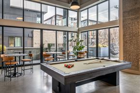 Seattle apartment for rent - A pool table is in the middle of a room with a view of the outside.