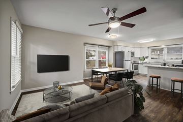 Chapel Hill apartment for rent - A living room with a grey couch and a ceiling fan.