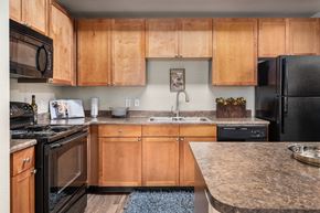 Phoenix apartment for rent - A kitchen with wooden cabinets and black appliances.