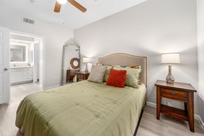 Phoenix apartment for rent - A bedroom with a bed, nightstand, and a ceiling fan.