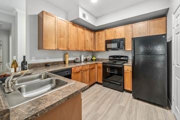 Phoenix apartment for rent - A kitchen with black appliances and wooden cabinets.