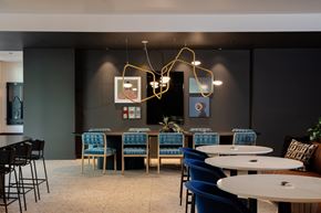 Hillsboro apartment for rent - A modern dining area with blue chairs and a long table.