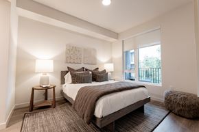 Burlingame apartment for rent - A bedroom with a large bed and a window overlooking a balcony.