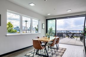Seattle apartment for rent - A dining room with a table and chairs and a view of the city.