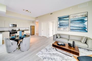 Hollywood apartment for rent - A modern living room with a dining table and a couch.