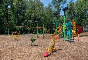 Roswell apartment for rent - Roswell Creek playground with colorful equipment and trees in the background
