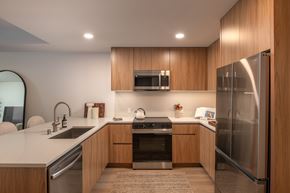 San Diego apartment for rent - A modern kitchen with wooden cabinets and stainless steel appliances.