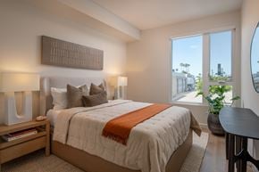 San Diego apartment for rent - A bedroom with a large bed and a view of the city.