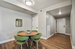 Boise apartment for rent - A dining room with a round table and green chairs.