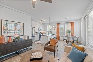 Katy apartment for rent - A living room with a brown sofa and a painting on the wall.