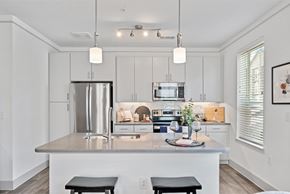 Katy apartment for rent - A modern kitchen with a stainless steel refrigerator and a center island.