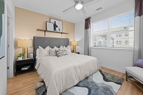 Raleigh apartment for rent - A bedroom with a large bed and a ceiling fan.