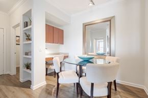 Aurora apartment for rent - A dining room with a glass table and white chairs.