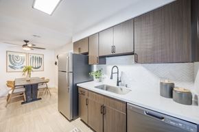 Henderson apartment for rent - A kitchen with modern cabinets, stainless steel appliances, and a dining table and chairs at Sage at Green Valley apartments.