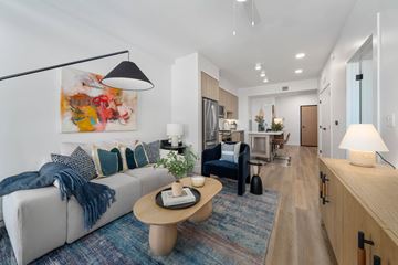 Phoenix apartment for rent - A modern living room with a grey sofa and a wooden coffee table.