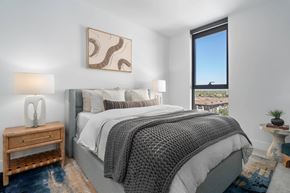Phoenix apartment for rent - A bedroom with a large bed and a view of the city.