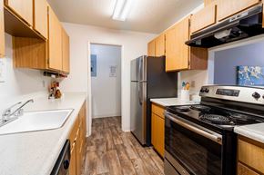 San Jose apartment for rent - A kitchen with wooden cabinets and a black refrigerator.