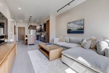 Lehi apartment for rent - A modern living room with a grey sofa and a wooden coffee table.