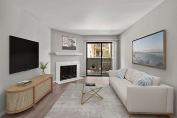 Santee apartment for rent - A living room with a white couch, a fireplace, and a painting on the wall.