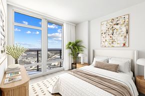 Vienna apartment for rent - A bedroom with a large bed and a view of the ocean through the window.