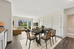 Washington apartment for rent - Contemporary apartment dining area featuring a minimalist black dining table and matching chairs under modern lighting.