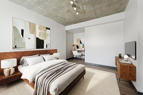 Washington apartment for rent - Spacious, brightly lit apartment bedroom with a large beautifully dressed bed, modern decor, and abstract wall art.