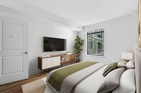 Arlington apartment for rent - A bedroom with a bed, a television, and a window.
