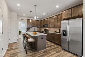 Sterling apartment for rent - A kitchen with wooden cabinets and a white refrigerator.
