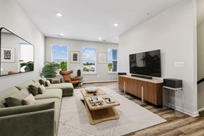 Sterling apartment for rent - A living room with a green couch, a wooden coffee table, and a flat screen TV.