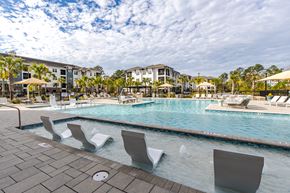 Johns Island apartment for rent - A pool with chairs around it and a building in the background.
