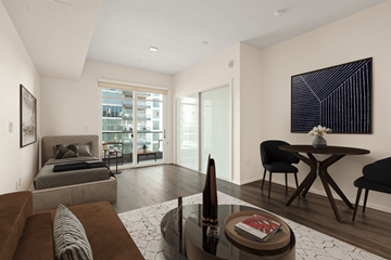 Long Beach apartment for rent - A modern living room with a grey sofa, a black chair, a coffee table, and a painting on the wall.
