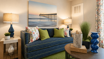 Myrtle Beach apartment for rent - A living room with a couch, a table, and a painting of a pier on the wall.