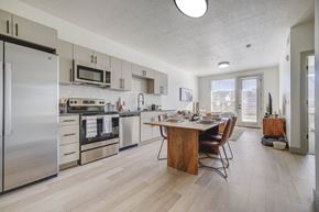 Heber apartment for rent - A modern spacious kitchen with a dining table and chairs, stainless steel appliances, and wood-style flooring