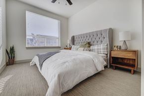 Heber apartment for rent - A spacious bedroom with a large bed and a wooden nightstand the room has large windows that provides a lot of natural light