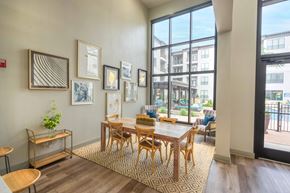 Dallas apartment for rent - a dining area with a wooden table and chairs and a large window with a view of a pool