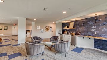 Richmond apartment for rent - A living room with grey chairs and a blue rug.