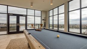 Richmond apartment for rent - A pool table with a yellow ball on it in a room with large windows.